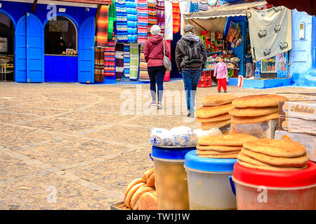 CHEFCHAOUEN, MOROCCO - APRIL 24, 2019: Colorful Moroccan fabrics and handmade souvenirs on the street in the blue city Chefchaouen, Morocco, Africa. Stock Photo