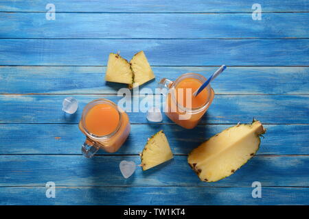 Fresh pineapple and mango cocktail in glasses on a blue rustic wooden background, copy space. Fresh cold pineapple and mango juice for summer Stock Photo