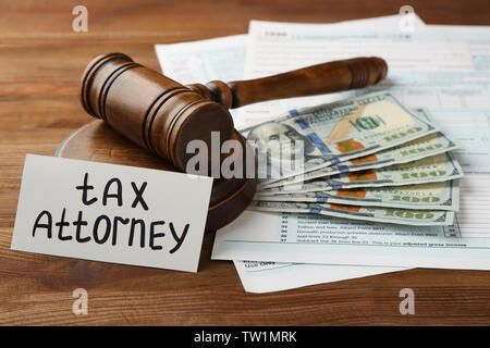 Card with text TAX ATTORNEY, judge's gavel and dollar banknotes on wooden background Stock Photo