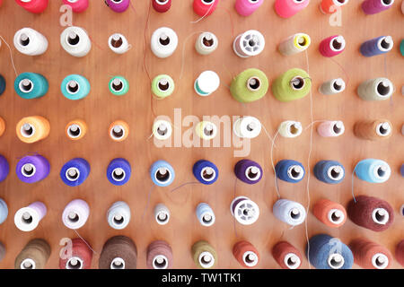 Spools with threads on rack, closeup Stock Photo