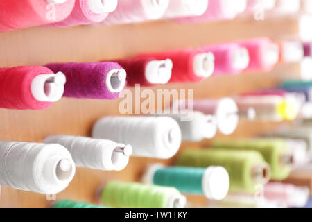 Spools with threads on rack, closeup Stock Photo