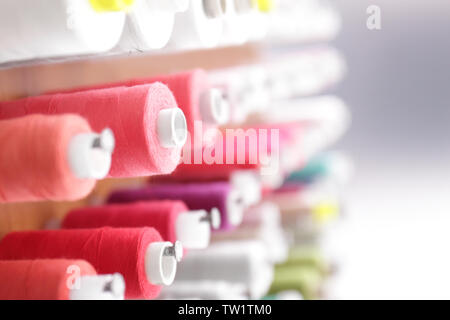 Spools with threads on rack, closeup Stock Photo