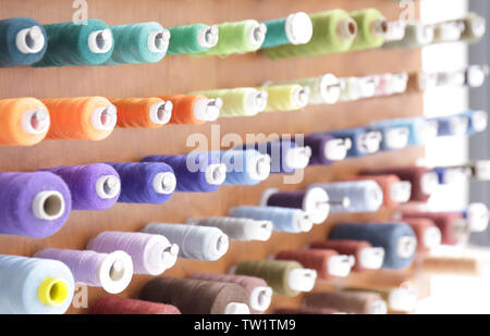 Spools with threads on rack, closeup Stock Photo