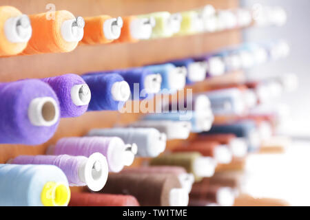 Spools with threads on rack, closeup Stock Photo