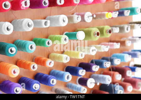 Spools with threads on rack, closeup Stock Photo