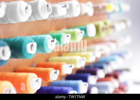 Spools with threads on rack, closeup Stock Photo