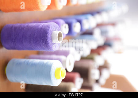 Spools with threads on rack, closeup Stock Photo