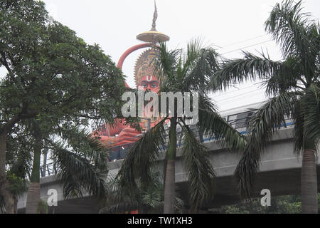 Low angle view of a statue of Lord Hanuman behind metro track, New Delhi, India Stock Photo