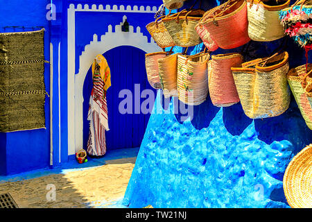 CHEFCHAOUEN, MOROCCO - APRIL 24, 2019: Colorful Moroccan fabrics and handmade souvenirs on the street in the blue city Chefchaouen, Morocco, Africa. Stock Photo