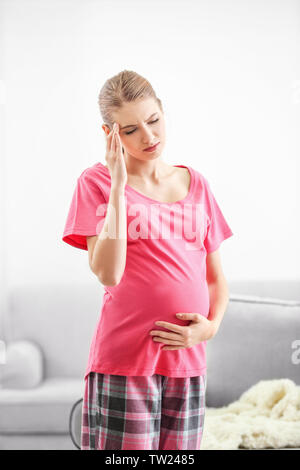 Pregnant woman suffering from headaches at home Stock Photo