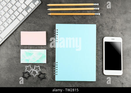 Notebook, business cards and smart phone on grunge background Stock Photo