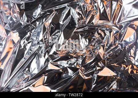 Abstract crumpled foil background. Grunge photo background. Orange shadows. Stock Photo