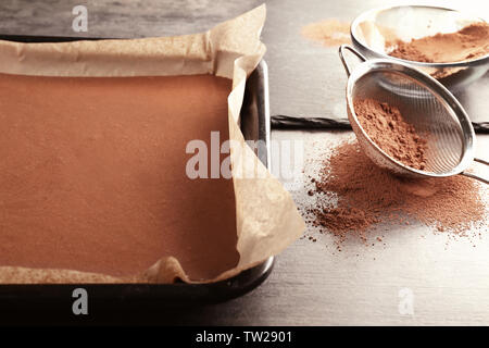 Unbaked cocoa cake in baking tray on table Stock Photo