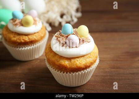 Tasty Easter cupcakes on wooden table Stock Photo