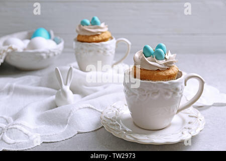 Delicious cupcake in porcelain cup on grey background Stock Photo