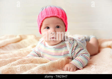 Cute little baby in hat lying on soft blanket Stock Photo