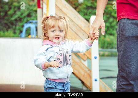 the father holds the hand of a daughter stand in the Park Stock Photo