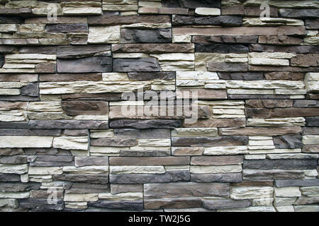 Stone wall texture background of narrow flat stones in brown, gray,beige colors Stock Photo