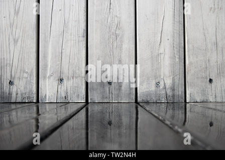 Wooden wall is reflected in water on of wooden flooring boards, abstract background in gray tones Stock Photo