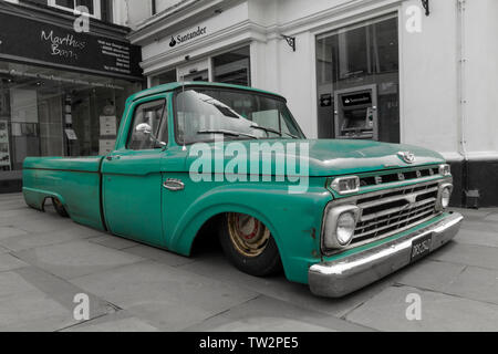 Lowered Ford pick up truck green colour color pop black and white conversion  extreme lowered body on public town centre vehicle event show Horsham UK Stock Photo