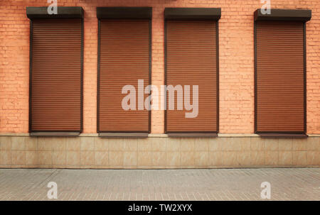 Windows with closed roller blinds in wall Stock Photo