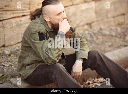 Bearded man smoking weed outdoors Stock Photo