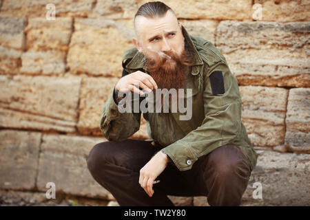 Bearded man smoking weed outdoors Stock Photo