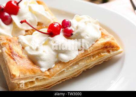 Tasty puff pastry dessert with berries and whipped cream on plate Stock Photo