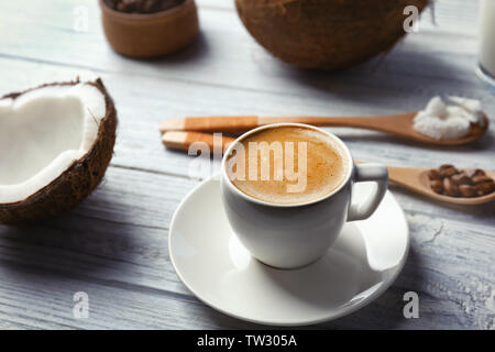 Cup with drink and ingredients for coconut coffee on wooden table Stock Photo