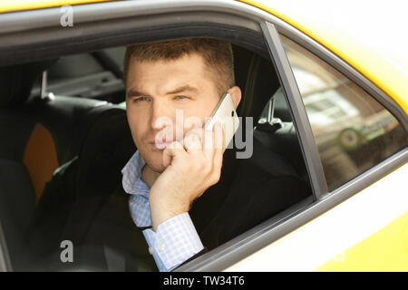 Handsome man talking on phone while sitting in car Stock Photo