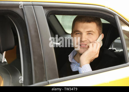 Handsome man talking on phone while sitting in car Stock Photo