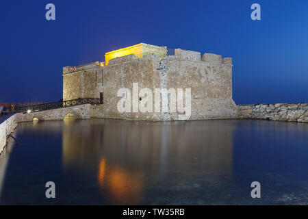 Illuminated Paphos Castle located in the city harbour at night with reflection in the water, Cyprus. Stock Photo