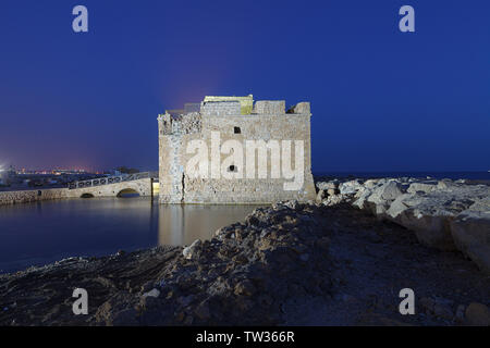 Illuminated Paphos Castle located in the city harbour at night with reflection in the water, Cyprus. Stock Photo