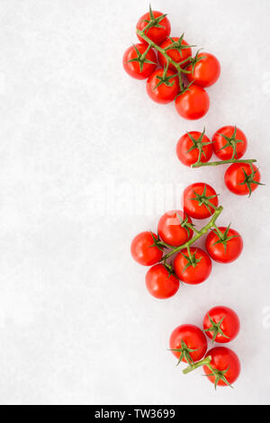 Top view of tomatoes on the vine on gray textured and patterned background with copy space. Stock Photo