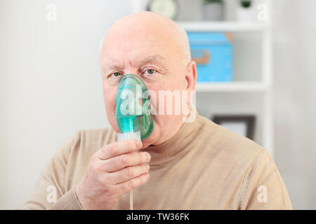 Senior man using asthma machine at home Stock Photo