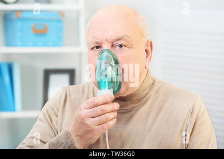 Senior man using asthma machine at home Stock Photo
