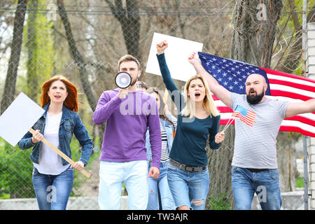 Group of protesting young people with American flag on street Stock Photo
