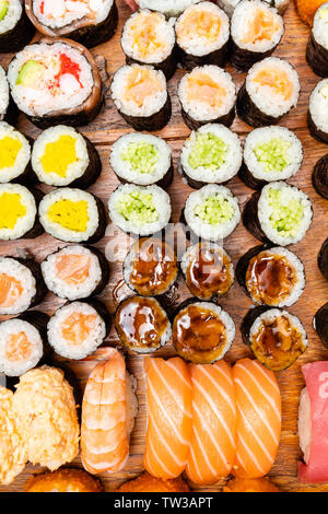 top view of big set of sushi and rolls on wooden table