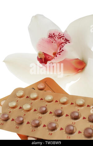 Oral contraception concept. Birth control pills and orchid flower on white background, closeup Stock Photo