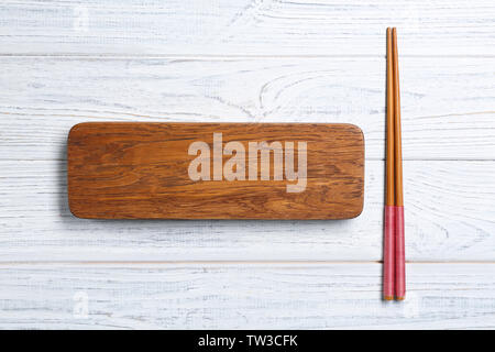 Rectangular wooden board and chopsticks on table Stock Photo