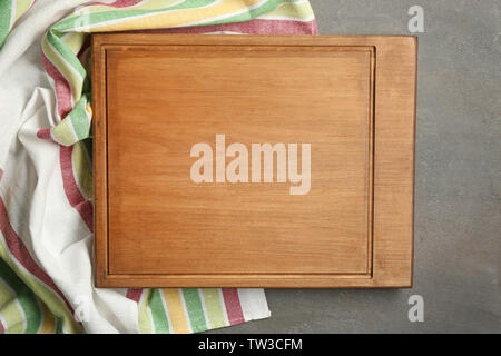 Wooden cutting board and cotton napkin on gray background Stock Photo