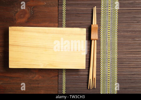 Rectangular wooden plate and chopsticks on table Stock Photo