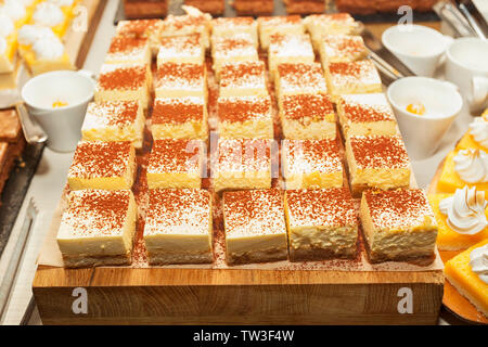 Small assorted cakes lined up decorated on dessert buffet. Sweet paradise. Stock Photo