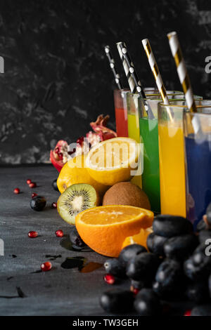 a set of cool fresh squeezed juices or cocktails in a glasses made from orange, kiwi, lemon, grapes, pomegranate Stock Photo