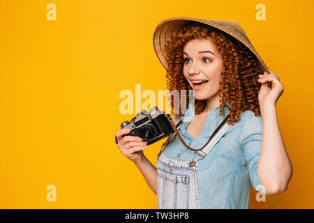 Tourist woman in straw hat with photo camera making surprised face.Traveler saying wow Stock Photo