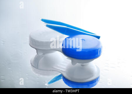 Container for contact lenses and tweezers on light background Stock Photo