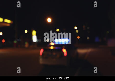 Blurred view of police car on road at night Stock Photo