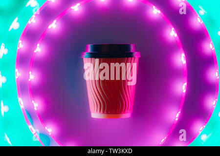 Coffee to go craft cup circling in led neon light. Stock Photo