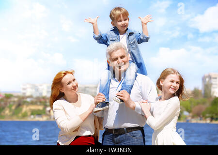Cute happy children with grandparents walking on embankment Stock Photo