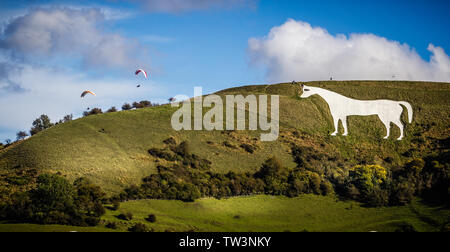 View of Westbury White Horse in Wiltshire, UK with  paragliders floating above Stock Photo